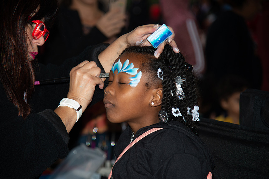 Girl getting face paint at winter fest